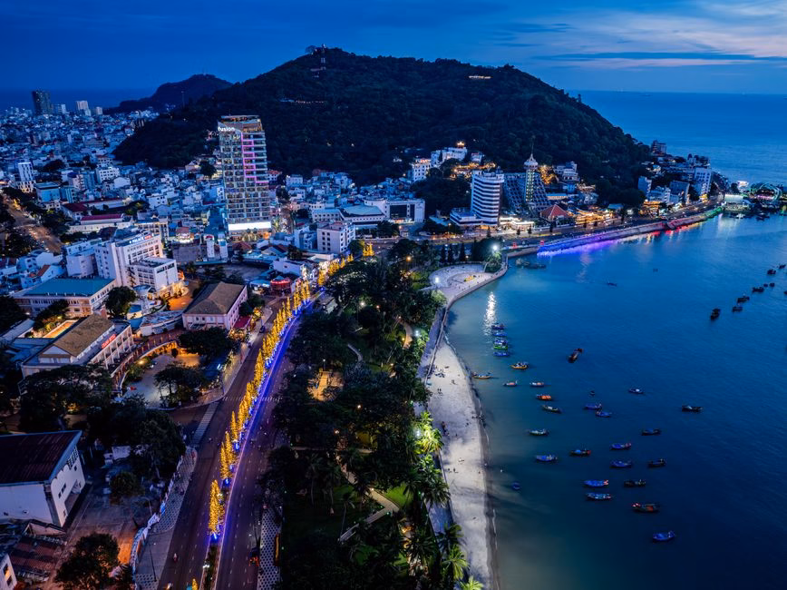 Stunning aerial view of Vung Tau city with illuminated streets and coastline at night.