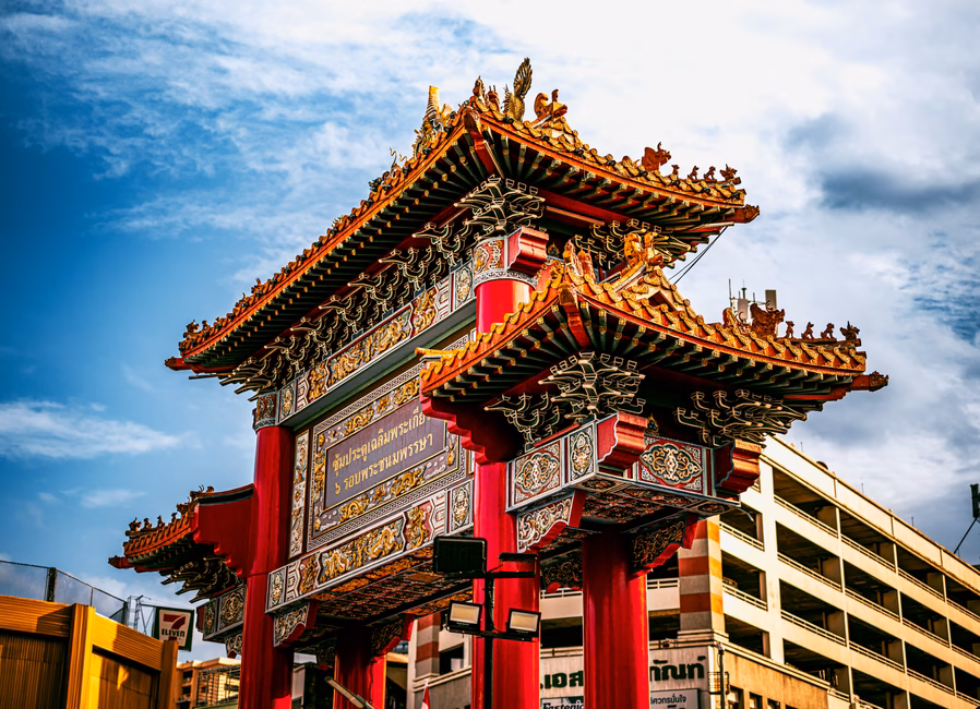 Vibrant Chinatown gate under clear sky in Bangkok, showcasing traditional architecture.