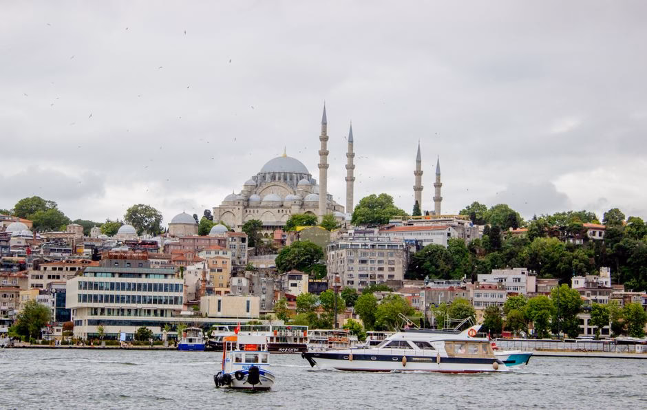 Captivating view of Istanbul's skyline with the Suleymaniye Mosque amidst urban landscape and boats on the Bosphorus.