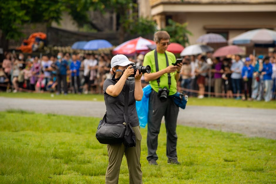 Photographers focusing on the vibrant scenes at Bac Ha Horse Racing Festival in Lào Cai, Vietnam.