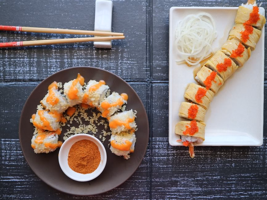 Delicious sushi rolls with spicy sauce presented on ceramic plates in East Java, Indonesia.