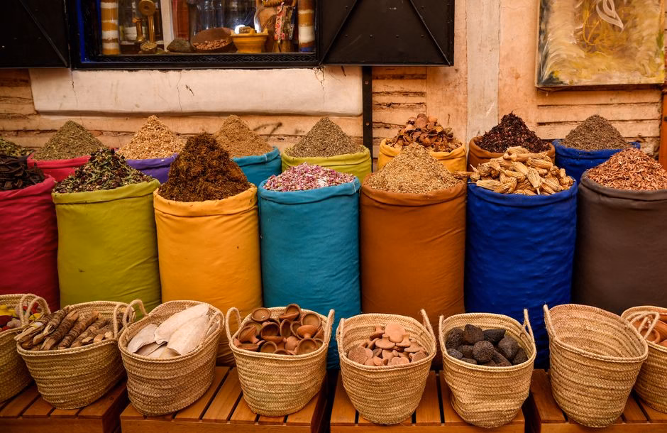 Colorful spice sacks in a Marrakesh souk depicting Moroccan culture.