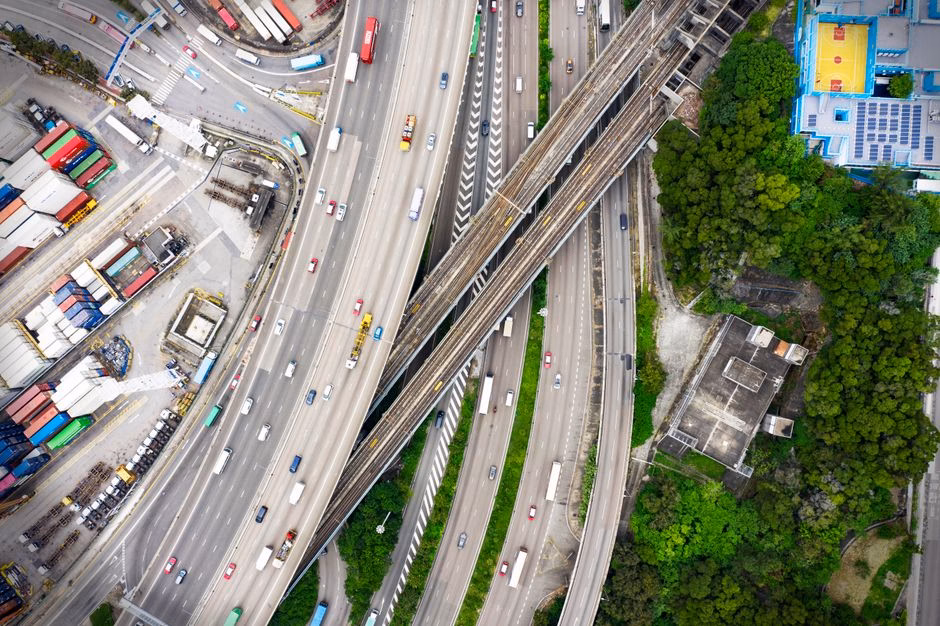 Aerial photo of a busy highway interchange in Hong Kong, showcasing urban infrastructure and traffic flow.